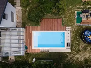 Laziness Prints: aerial drone flight over beautiful green garden with pool and the wooden deck of the pool is in progress
