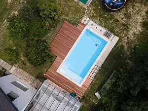Laziness Prints: aerial drone flight over beautiful green garden with pool and the wooden deck of the pool is in progress