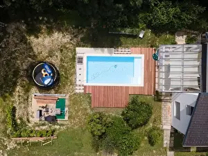 Laziness Prints: aerial drone flight over beautiful green garden with pool and the wooden deck of the pool is in progress