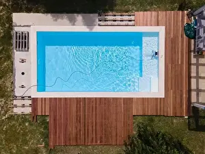 Laziness Prints: aerial drone flight over beautiful green garden with pool and the wooden deck of the pool is in progress