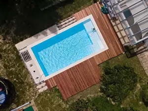 Laziness Prints: aerial drone flight over beautiful green garden with pool and the wooden deck of the pool is in progress