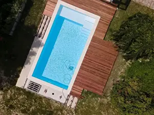 Laziness Prints: aerial drone flight over beautiful green garden with pool and the wooden deck of the pool is in progress