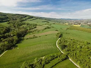 Hill Spring Prints: aerial drone flight over green meadows and forest in lower austria
