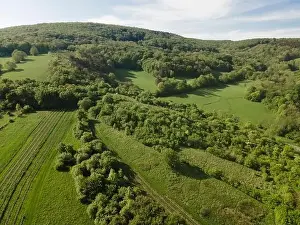 Hill Spring Prints: aerial drone flight over green meadows and forest in lower austria