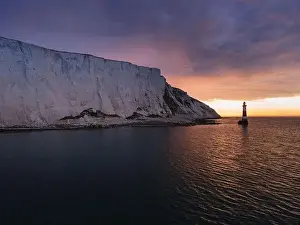 Seven Sisters Prints: Aerial Drone Landscape photo of a Beachy Head Lighthouse and chalk cliffs at colorful sunrise with low tide in England