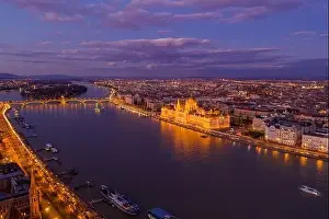 Beautiful Sky Prints: Aerial drone of lighted Hungarian Parliament by Danube river in Budapest sunset hour