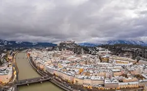Salzach Prints: Aerial drone overview of Salzburg old town skyline covered with snow and view of Hohensalzburg in Austria winter
