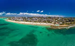 Aerial drone panoramic image of ocean waves on a busy Kings beach, Caloundra, Queensland, Australia