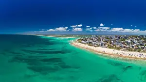 Aerial drone panoramic image of ocean waves on a busy Kings beach, Caloundra, Queensland, Australia
