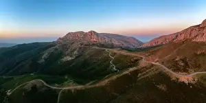 Mountainscape Prints: Aerial drone panoramic view of a camper van on a mountain road at sunset