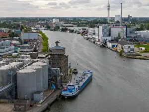 Cargo Ship Prints: Aerial drone photo of a cargo barge docked at an industrial zone in Wormerveer