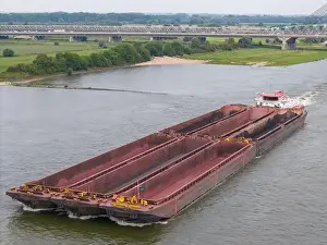Cargo Ship Prints: Aerial drone photo of a large cargo barge sailing on the river Waal in the Netherlans