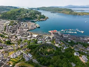 Oban Prints: An aerial drone photo of the Mccaig's tower in Oban with a beautiful view over town and the bay