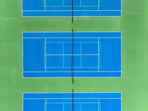 Aerial, drone, photo of new outdoor blue tennis court with white lines combined with light blue pickleball lines