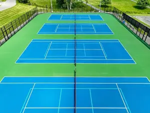 Retaining Prints: Aerial, drone, photo of new outdoor blue tennis court with white lines combined with light blue pickleball lines