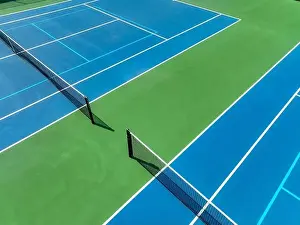 Aerial, drone, photo of new outdoor blue tennis court with white lines combined with light blue pickleball lines