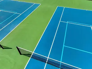 Retaining Prints: Aerial, drone, photo of new outdoor blue tennis court with white lines combined with light blue pickleball lines