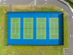 Aerial, drone, photo of new outdoor green tennis courts with white lines and blue out of bounds area