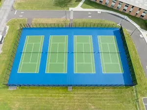 Aerial, drone, photo of new outdoor green tennis courts with white lines and blue out of bounds area