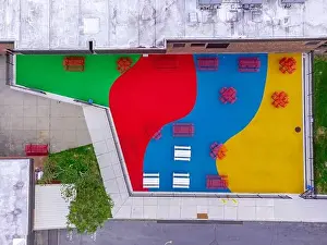 Equity Prints: Aerial, drone, photo, of a red vinyl coated picnic tables on a multi color playground surface
