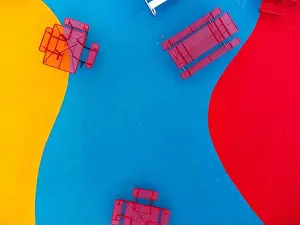 Equity Prints: Aerial, drone, photo, of a red vinyl coated picnic tables on a multi color playground surface