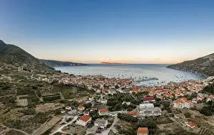 Vis Island Prints: Aerial drone shot of adriatic sea Komiza town on Vis Island with view of Bisevo Island in Croatia summer sunrise