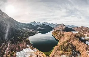Snow Mountain Prints: Aerial drone shot of Alpsee lake in Fussen with view of Alps snow mountain range in Germany winter