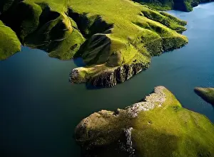Blue Beach Prints: Aerial drone shot of beautiful scenery of blue mountain lake with green hills at sunset light glow in Tien Shan