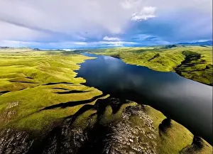 Blue Beach Prints: Aerial drone shot of beautiful scenery of blue mountain lake with green hills at sunset light glow in Tien Shan