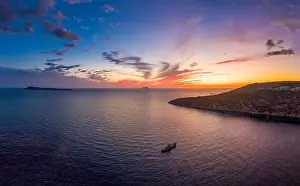 Burning Clouds Prints: Aerial drone shot of boat drifting in Adriatic sea with sunset burning sky on Komiza over Vis Island in Croatia Summer