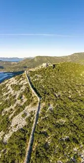 Aerial drone shot of City Wall of Ston over hill to Mali Ston in Croatia summer morning sunrise