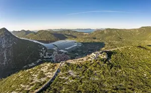 Salt Pan Prints: Aerial drone shot of Fortress of City of Ston on top of hill with view of Salt Pans in Croatia sunrise
