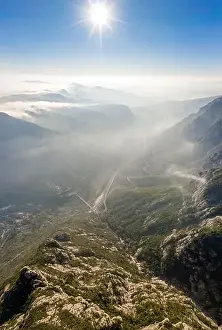 Benedictine Prints: aerial drone shot of highway through Montserrat mountain near Barcelona with morning fog