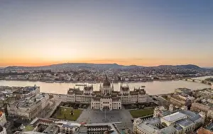 Neo Gothic Prints: Aerial drone shot of Hungarian Parliament by Danube river in Kossuth Square in Budapest sunset