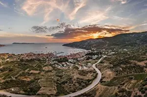 Residents Prints: Aerial drone shot of Komiza town with sunset burning sky on Vis Island in Croatia summer