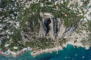 Anacapri Prints: Aerial drone shot of mountain top villa with pool above big mountain hole cave in south Capri Island