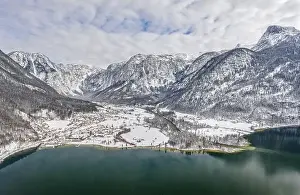 Northern Limestone Alps Prints: Aerial drone shot of Obertraun village in snow mountain valley by Hallstatt lake in Austria in winter