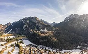 Fussen Prints: Aerial drone shot of picturesque Neuschwanstein Castle on snowy hill in winter sunlight in Germany