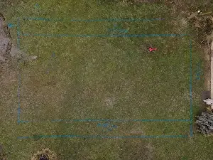 Mover Prints: aerial drone shot of small, yellow excavator stands in a large garden and digs a hole for a pool in austria
