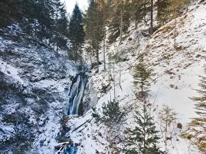 Aerial drone shot of snowy and icy winter landscape in the oetschergraeben
