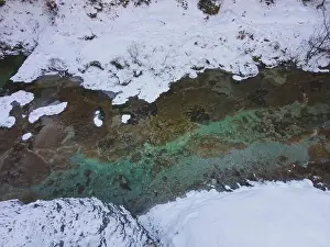 Aerial drone shot of snowy and icy winter landscape in the oetschergraeben