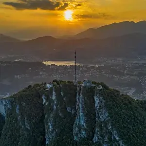 Aerial Cityscape Prints: Aerial drone shot view of top of monte salvatore with sunset and Varese village