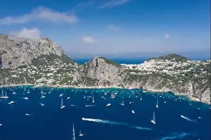 Faraglioni Prints: Aerial drone shot view of southern coastline of Capri Islan in Tyrrhenian sea with yachts