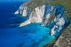 Noon Prints: Aerial drone shot of Zakynthos Navagio beach cliffs by blue Ionian sea in summer