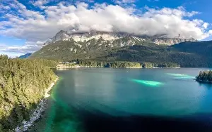 Garmisch Prints: Aerial drone shot of Zugspitze covered with heavy fog by Eibsee Lake in Germany