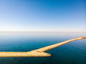 Blue Beach Prints: Aerial drone view of a breakwater and a lighthouse in Denia port, Spain