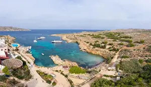 Honed Prints: Aerial drone view Comino, Malta Blue Lagoon to enjoy the clear turquoise water with clear blue sky and boats in summer