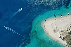 Aerial drone view of iconic small uninhabited island of Marathonisi featuring clear water, sandy shore and natural hatchery of Caretta-Caretta sea tur