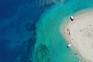 Aerial drone view of iconic small uninhabited island of Marathonisi featuring clear water, sandy shore and natural hatchery of Caretta-Caretta sea tur