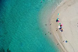 Aerial drone view of iconic small uninhabited island of Marathonisi featuring clear water, sandy shore and natural hatchery of Caretta-Caretta sea tur